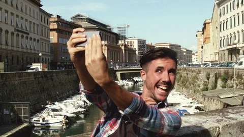 Making selfie, young man taking a selfie making crazy face  Stock Footage 80303534
