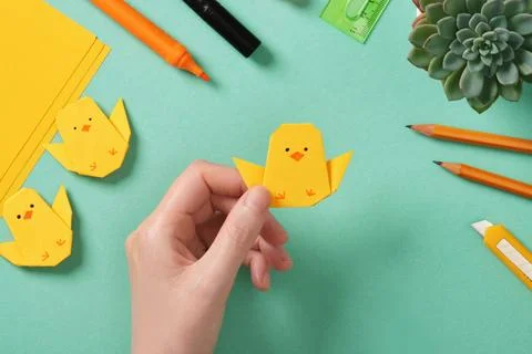 Making a simple Easter origami handicraft. Holds in his hand a ready-made p.. Stock Photos