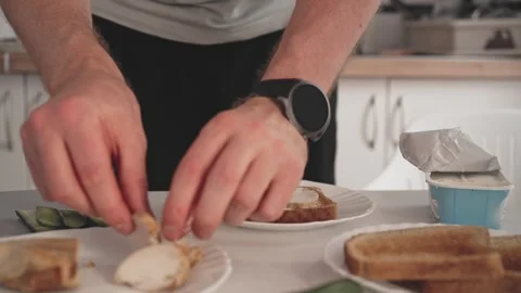 Making a simple meal with bread, chicken, and vegetables in a kitchen at midd Stock Footage 340193576