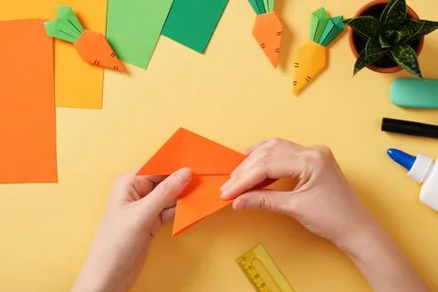 Making a simple origami carrot Easter craft. Fold the corners of the triang.. Stock Photos