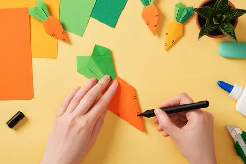 Making a simple origami carrot Easter craft. With a black felt-tip pen, dra.. Stock Photos