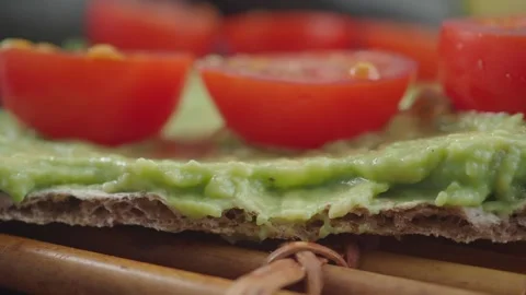 Making a simple snack with tomatoes and avocados on bread Видео 337286315