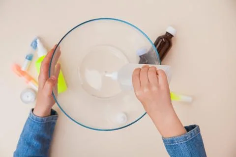 Making slime, step by step instruction, step one, adding stationery glue. Stockfoto's