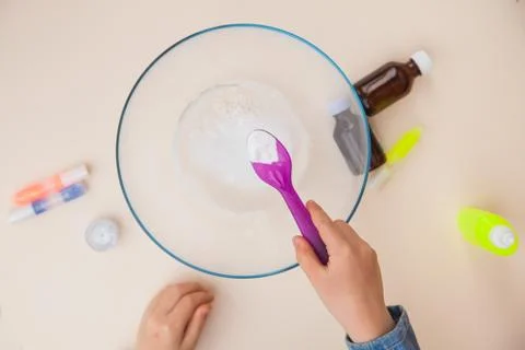 Making slime, step by step instruction, step two, adding soda. 库存照片