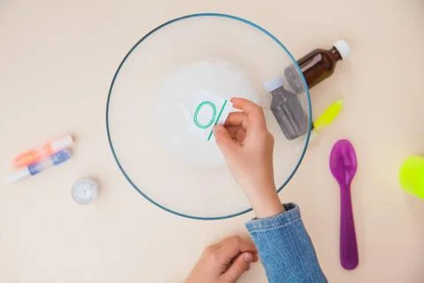 Making slime, step by step instruction, step three, adding food dye. Fotos Stock