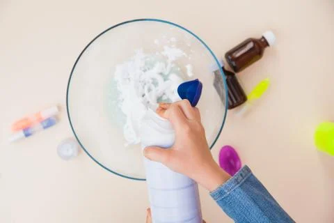 Making slime, step by step instruction, step four, adding shaving foam. 库存照片