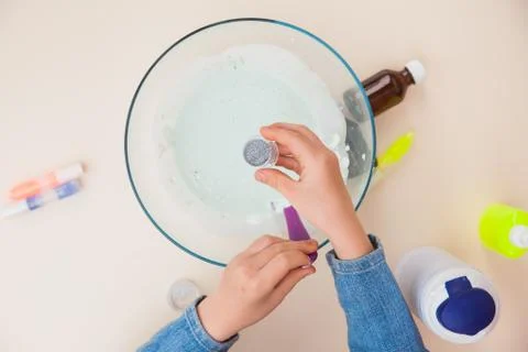 Making slime, step by step instruction, step six, adding glitter. Stockfoto's