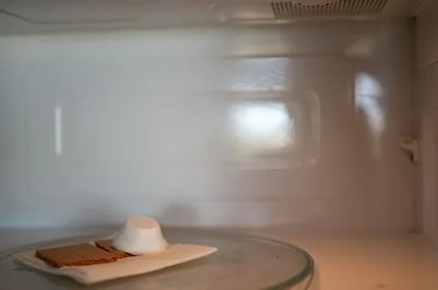 Making a smore with a marshmallow, cracker, and chocolate using a microwave. Foto stock