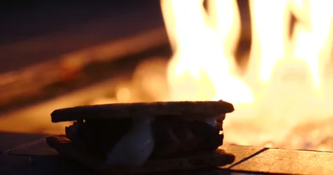 Making s'mores by the campfire at dusk Stock Footage 281816228