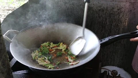 Making stir fried pork, mixed vegetables in metal pan with spatula and hot oil Stock Footage 141306302