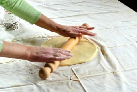 Making of a strudel, preparing dough with rolling pin on a kitchen table Foto stock