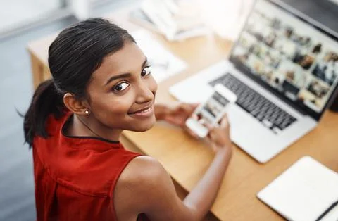 Making sure her devices are synchronised. High angle shot of a young beautiful Stock Photos