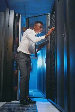 Making sure my system is still running smoothly. Full length shot of a young IT Stock Photos