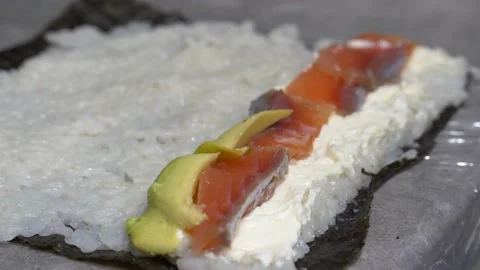 Making sushi roll with red fish avocado and cheese Video stock 232944291