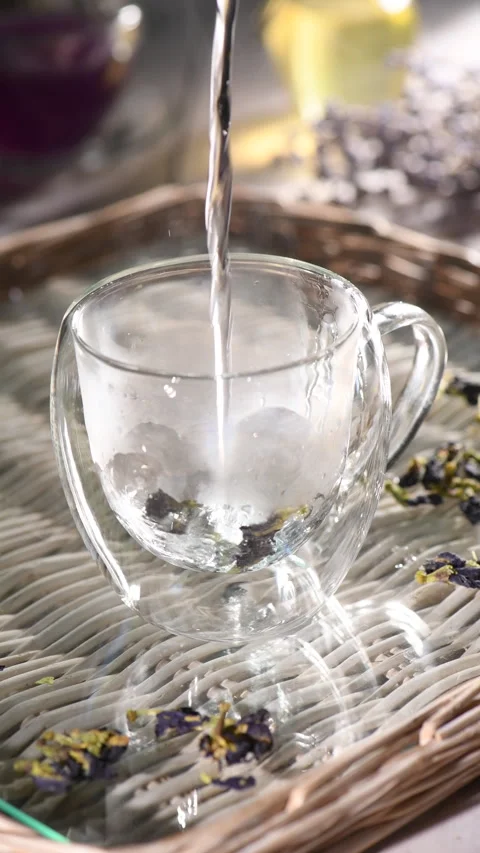 Making tea from Clitoria ternatea flowers in a clear glass cup. Stock Footage 340233789