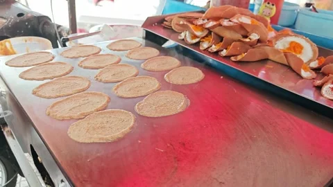 Making Thai crispy pancakes or Khanom Buang on a hot griddle. Stock Footage 345292349