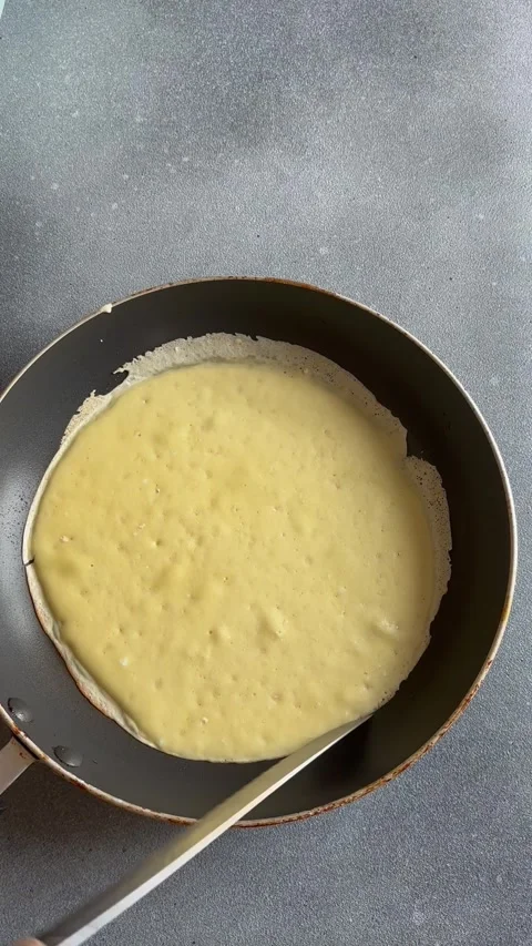 Making thin pancakes on frying pan in kitchen Stock Footage 255865647