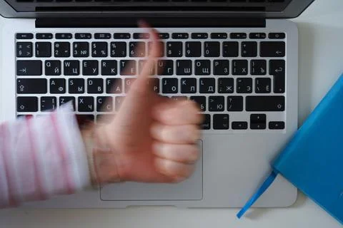 Making thumbs up sign on keyboard background. Blue dairy Stock Photos