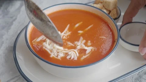 Making tomato soup with cheese topping at home Stock Footage 339382927