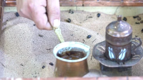 Making turkish coffee in copper cezve over hot sand. Milling of grains. Vidéo 84921600