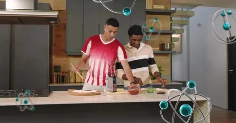 Making two men red-shirt beige-pullover assembling dough on board at kitchen Stock Photos