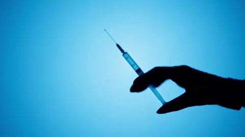 Making vaccination injection, shadow of doctor holding syringe close-up Video stock 169734566