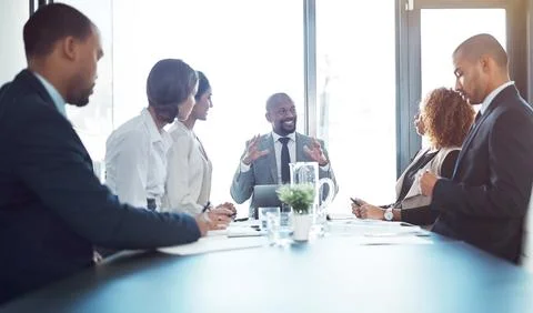 Making valid points that add value. a team of professionals having a meeting in Stock Photos