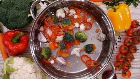 Making a vegetable soup, ingredients falling into cooking pot Stock-Footage 102297967