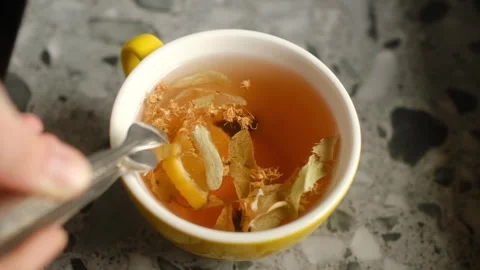 Making warm herbal tea with lemon wedges and dried flowers. Stock Footage 325536895