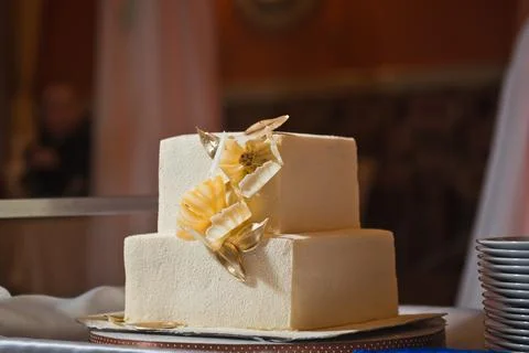 Making a wedding cake with white and gold flowers made of mastic 2544. Stock Photos