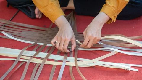 Making woven items using plastic ribbon. Crafts made from recycled materials. Fotos Stock