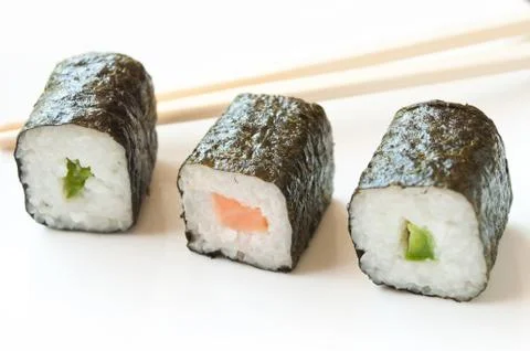 Makis and chopsticks on white background Stock Photos