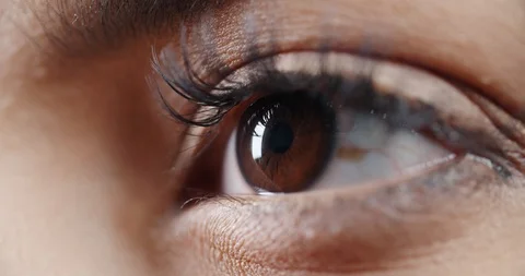 Makro shot of female eye with makeup on eyelashes and dark brown iris opening Stock Footage