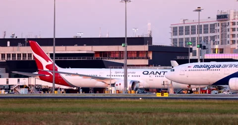 Malaysia Airlines Airbus A330 airplane taxiing past a Qantas Boeing 787 Stock Footage 155113761