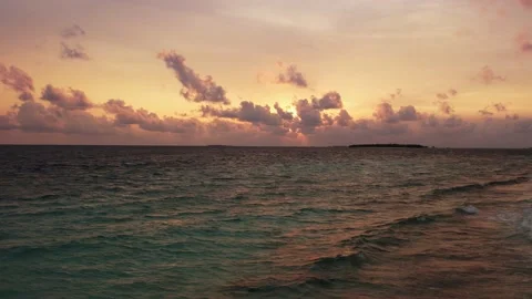 Maldives sunset over ocean, panoramic orange sky and island 動画素材 168319242