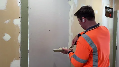 Male in 30's applying plastering compound to a wall Vídeo Stock 297590481