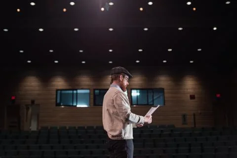 Male actor reading script on stage Stock Photos