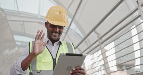 Male American engineer standing using tablet to inspect building construction Stock Footage 259813719