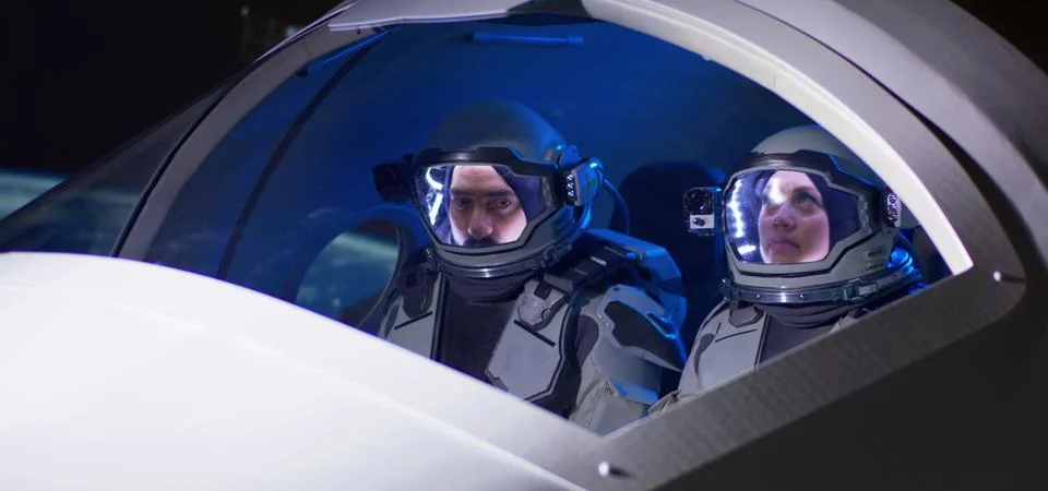 Male and female astronauts navigating spaceship Stock Photos