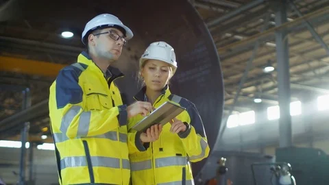 Male and Female Industrial Engineers in Hard Hats Discuss New Project. Stock Footage