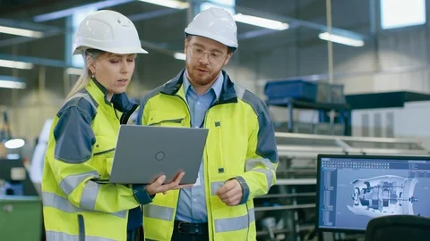 Male and Female Industrial Engineers Wearing safety, Work on a Factory Stock Footage