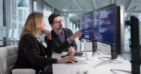 Male And Female Programmers Developing Cybersecurity Software In Office Stock Photos