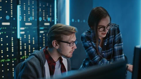 Male and Female Programmers Talking, Solving Problem, Using Computers. Software Stock Footage 103274880