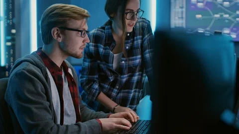Male and Female Programmers Talking, Solving Problem, Using Computers Stock Footage 103275004