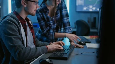 Male and Female Programmers Talking, Solving Problem, Using Computers. Software Stock Footage 103275208