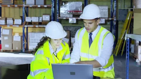 Male and female warehouse workers discuss the logistics of their business Stock Footage