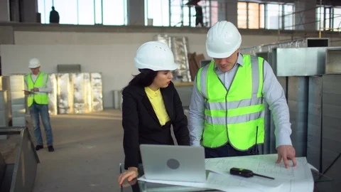 Male and female warehouse workers are looking at a laptop computer and Stock Footage