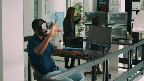 Male app developer using virtual reality glasses to code new server interface 動画素材 217409540