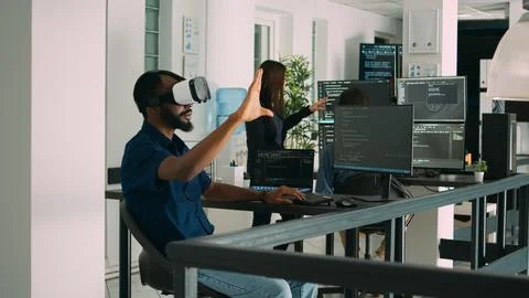 Male app developer using virtual reality glasses to code new server interface Stock Photos