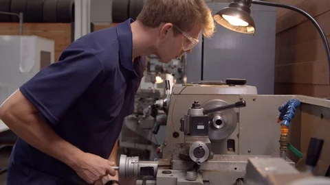 Male Apprentice In Factory Using Lathe Shot In Slow Motion Video stock 72512640